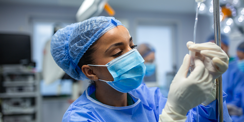 Anesthesiologist adjusting an IV line in the operating room.