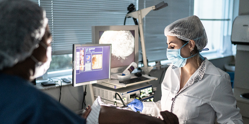 Endoscopy technician assisting with a procedure while monitoring the screen.