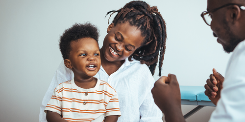 Family physician talking with patients in a clinic setting.