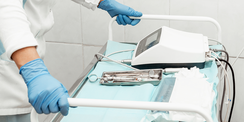 Medical worker pushing a cart with sterilized equipment and instruments.