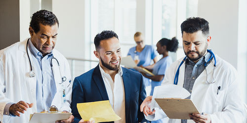 Medical records specialists reviewing patient charts in an office.