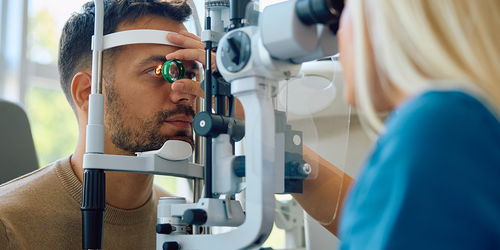 Ophthalmologist performing a slit‑lamp eye exam on a patient.