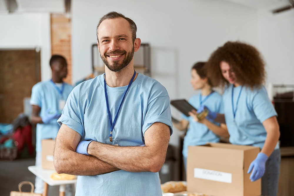 Portrait of male volunteer in blue uniform and gloves smiling
